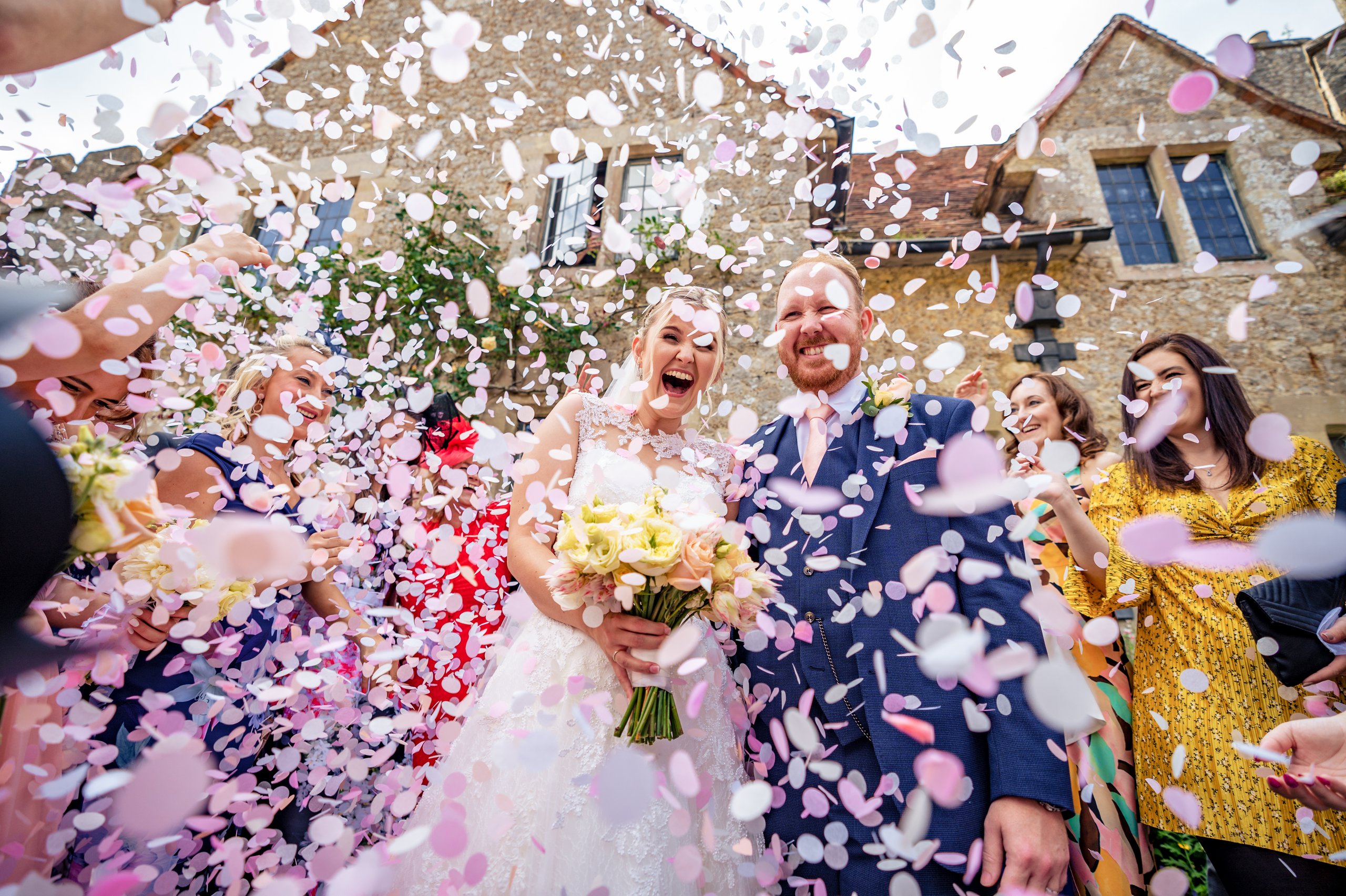 Joyful couple surrounded by a shower of confetti after their ceremony