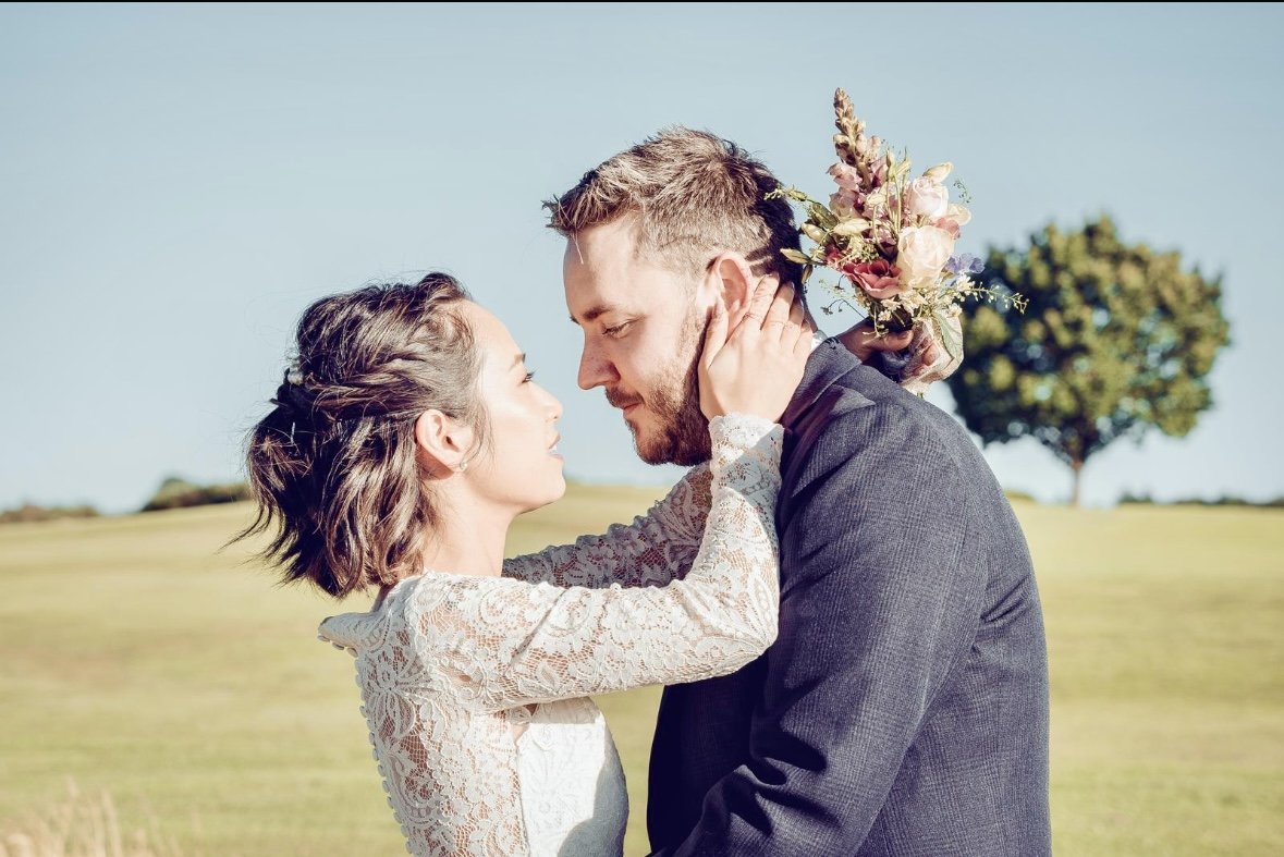 Couple in a scenic field on their wedding day